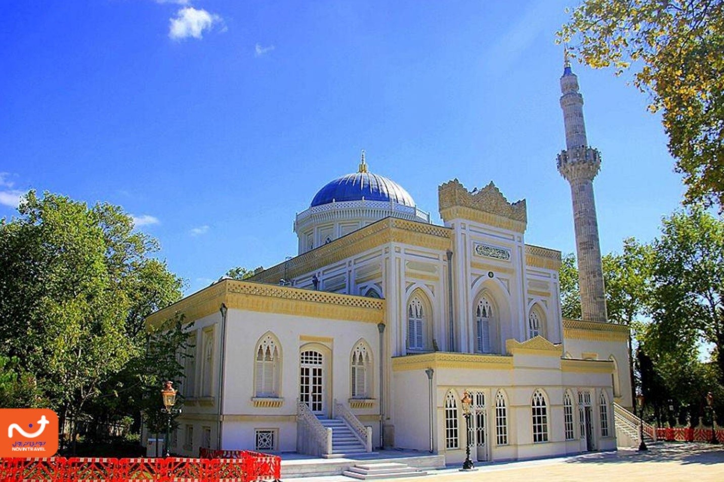 مسجد ییلدیز با گنبد آبی و معماری زیبا در میان درختان سرسبز و آسمان آبی.